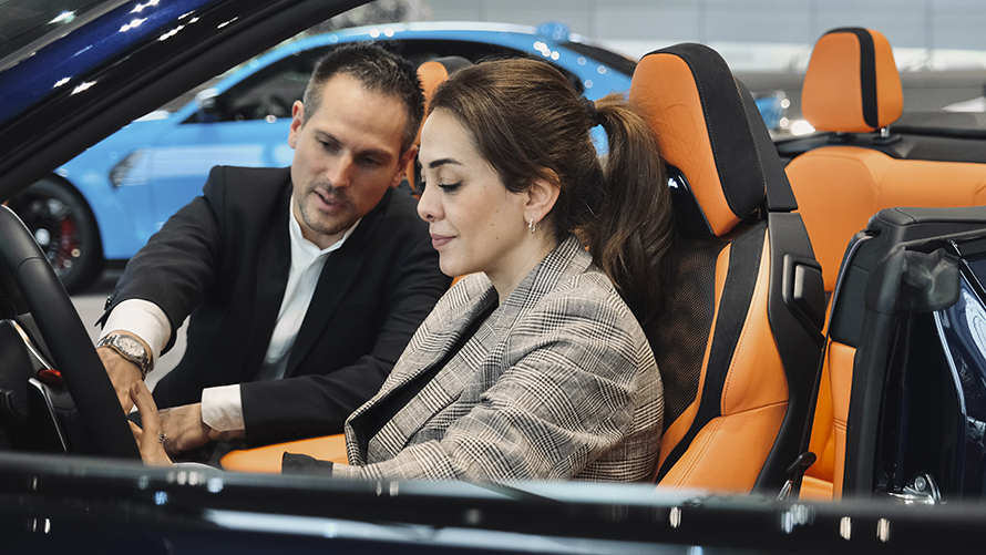 BMW Welt Fahrzeugberater BMW Welt Fahrzeugberater erklärt Kundin die Funktionen eines BMW.