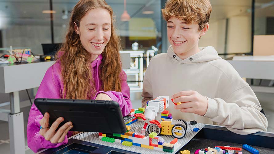 BMW Programmierworkshop Familien Jugendliches Mädchen und Junge bauen gemeinsam an einem Lego-Roboter