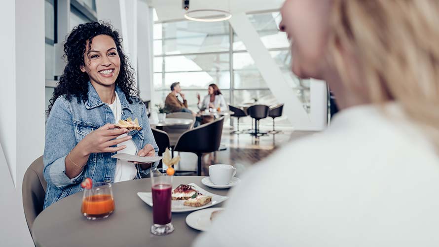 Zwei Frauen genießen Speisen in der Premium Lounge der BMW Welt