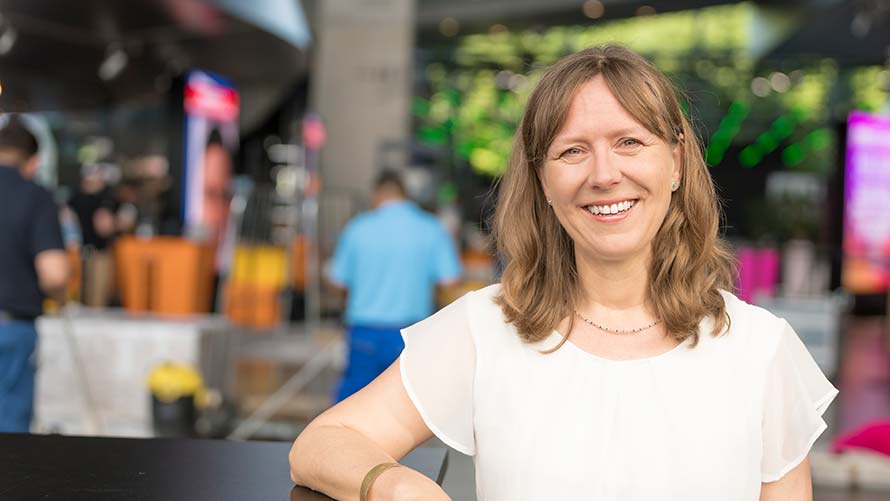 Frau berichtet lächelnd von ihren Event-Erfahrungen in der BMW Welt