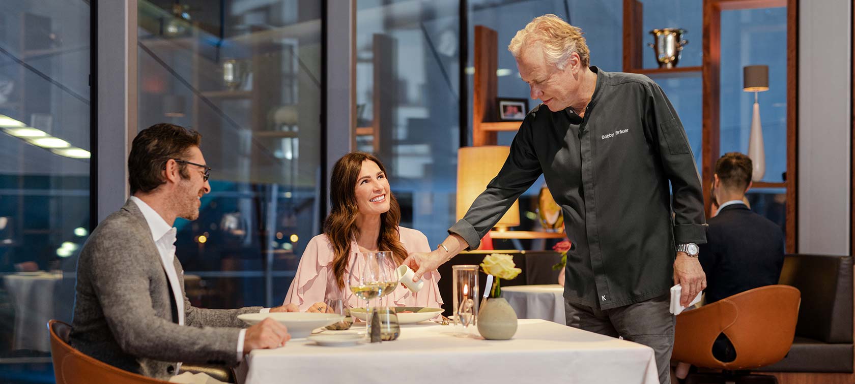 two happy guests enjoy a meal in the bmw welt restaurant