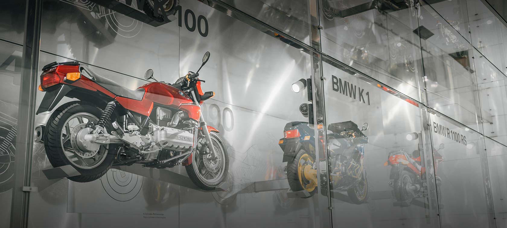 BMW Motorrad Wandinstallation diverser BMW Motorräder wie die BMW K 100 in rot und die BMW K1 in blau sowie gelb im BMW Museum