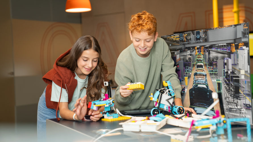 BMW Familien und Kinder Programmierworkshops Mädchen steuert einen kleinen Lego-Roboter mit Hilfe eines Tablets