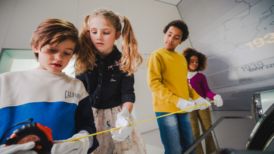 BMW Familien und Kinder Detektivworkshop Kinder vermessen Fahrzeuge im BMW Museum, um Hinweise zu finden