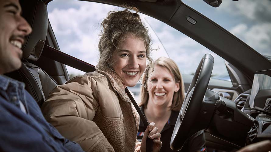 BMW M Driving Experience Frau lächelt strahlend beim BMW M Driving Experience Erlebnis.