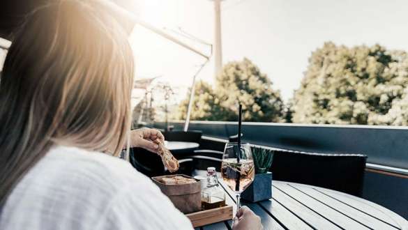 frau genießt aperitif auf aussichtsterrasse der bmw welt