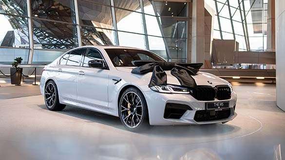 BMW M5 Abholung Weißer BMW M5 mit schwarzer Schleife auf der Abholungsplattform der BMW Welt