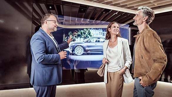 Fahrzeugexperte zeigt glücklichem Paar die virtuelle Animation Ihres BMW im Product Info Center Classic Ausstellung im BMW Museum