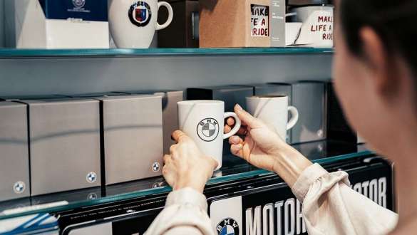 employee puts cup on shelf in bmw welt store employee puts cup on shelf in bmw welt store