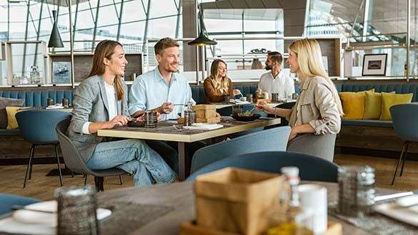 BMW Welt Bavarie Zwei Frauen und ein Mann genießen Speisen in der Bavarie in der BMW Welt