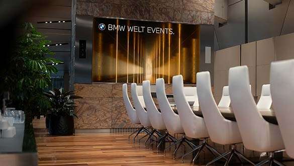 Videotechnik Konferenzraum mit großem Tisch und Bestuhlung im Business Club mit großem Screen in der BMW Welt