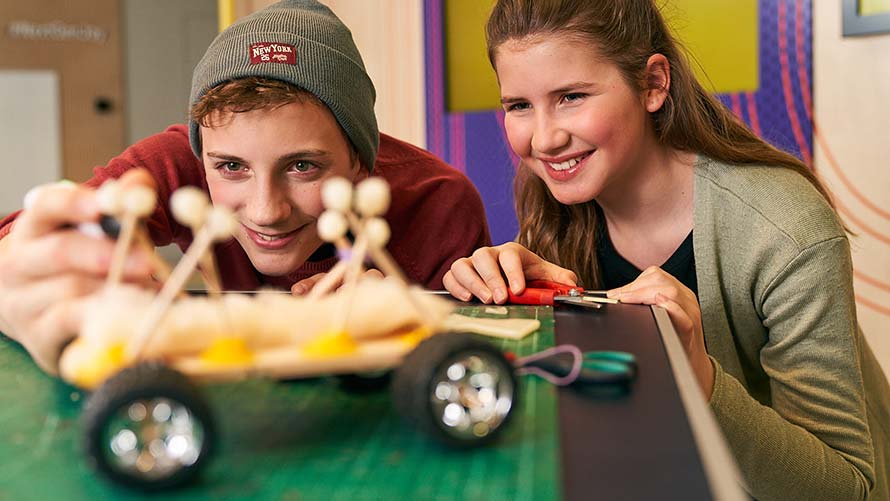 BMW Kreativworkshop ab 14 Jahre Jugendlicher Junge und Mädchen basteln gemeinsam an Automodell aus Holz