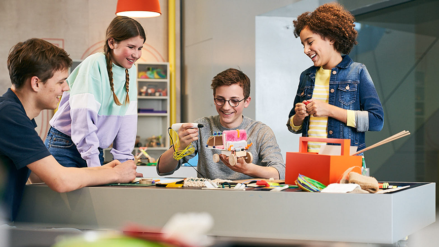 BMW Schulen Workshops Kinder basteln an einem futuristischen Auto im BMW Kreativworkshop